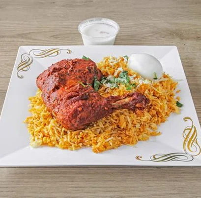 Chicken biryani with a fried chicken leg, boiled egg and raita