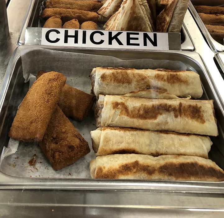 Crumb-fried chicken rolls and grilled roti wraps in the counter tray
